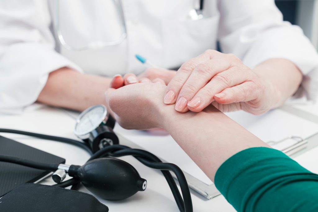 Doctor checking patient pulse