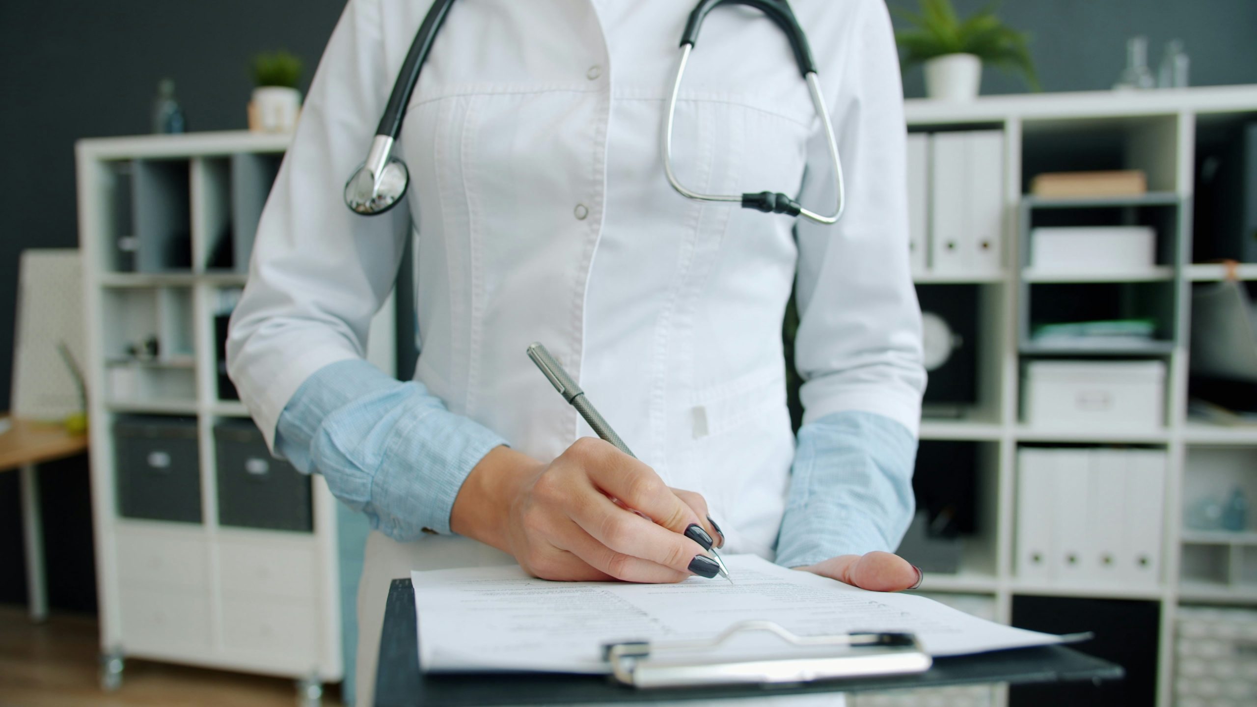 Physician signing patient forms
